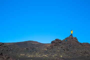 A Man photographe on a peak mountain against a blue sky