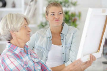 senior woman looks at photo frame with daughter