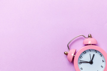 Ringing twin bell vintage classic alarm clock Isolated on purple violet pastel colourful...