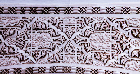 Beautiful complex exquisite carving on the plastered white walls of the Bahia Palace in the southeastern part of the medina of Marrakesh. Morocco Africa