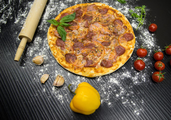 pepperoni pizza with tomato and cheese on black background