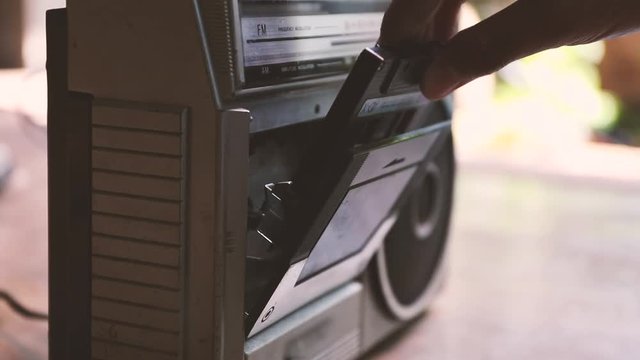 man push play button on a retro music player
