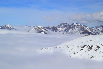 Fototapeta na wymiar Mountain peaks over clouds. Landscape in Grandvalira ski area, Andorra.