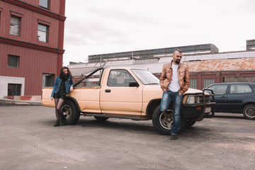 frustrated young couple standing near their car