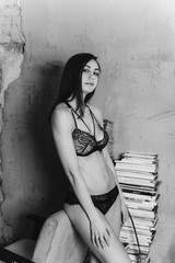 Sexy lady in lace lingerie with long black hair looking at camera. Black and white photo
