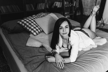 Fototapeta premium Sexy lady in lace lingerie with long black hair looking at camera. Black and white photo