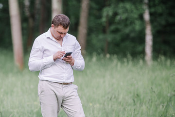 man uses a smartphone for a walk in the Park.
