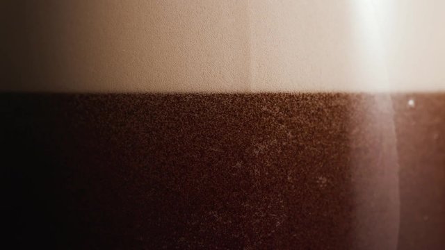 Macro dark beer settling in a glass