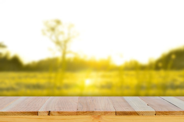 Wood table top on blur grass background   background .summer,nature concepts.field of grass and sun in morning