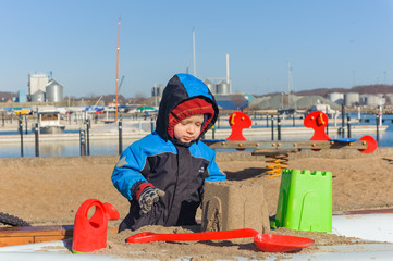 boy playing with sand on plauground