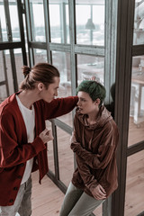 Fototapeta premium Young woman with short hair cut looking at nervous angry husband