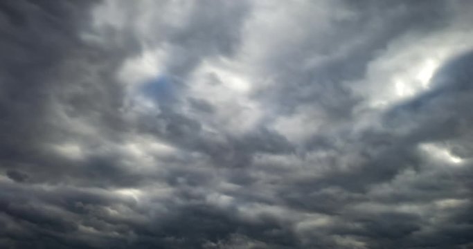 Time lapse clip of gray fluffy curly rolling clouds before storm in windy weather