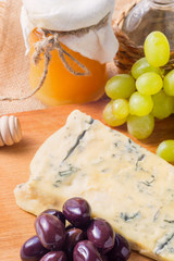 White cheese plate with honey, grapes, olive . Assortment of wine snack, appetizer or gourmet dinner.