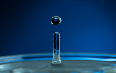 splash from a falling drop of water in a glass on a dark background