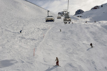 Fototapeta na wymiar People skiing and going up the mountain by chairlift at Engelberg on the Swiss alps
