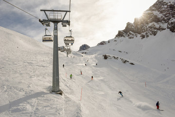 People skiing and going up the mountain by chairlift at Engelberg on the Swiss alps