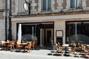 Old street with old houses and tables of cafe in a small town Chartres, France