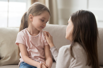 Obraz na płótnie Canvas Loving mom talking to upset little child girl giving support