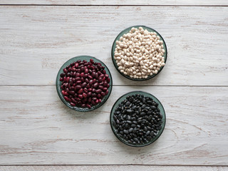 Black, red and white beans flat lay on a table.