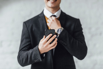 Positive office worker advertising mobile app. Young caucasian man showing smartphone with copy space. Lifestyle!