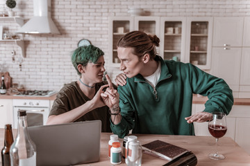 Husband calming his hysterical wife addicted to alcohol