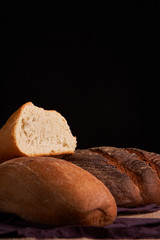 Different bread and wheat on the rustic table. Selective focus, close up