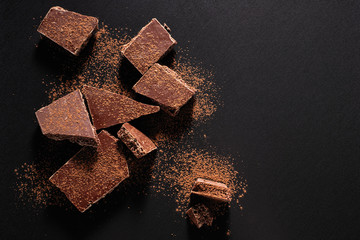 broken chocolate bar on black background