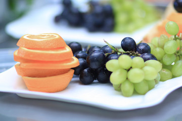 close up.plates with grapes and fruits on blurred background