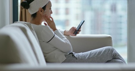 Woman apply the paper mask and use of mobile phone