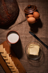 Assorted dairy products milk, cheese, butter rustic still life on table