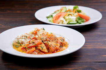 meat with barley and salad on the wooden background