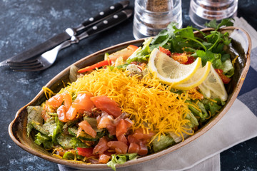 Salted salmon and fresh vegetables with yellow cheese on a plate. Tasty salmon salad