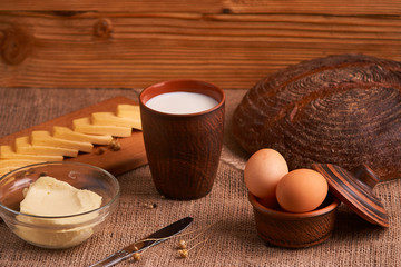Eggs with bread and kitchen utensils on vintage wooden background. Tasty food
