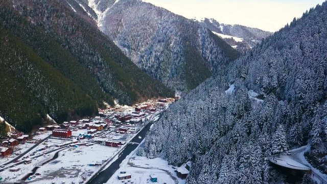 hd drone aerial shot, dolly sideways, in a canyon, river in the middle, snowy weather, white forests, in Turkey