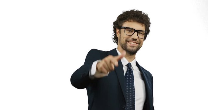 Attractive Caucasian businessman in the suit, tie and glasses smiling and pointing his finger to the camera like you super! On the white screen background.