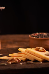 Peppercorns in a wooden bowl on table with cheese. Homemade food