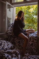 Fototapeta premium Junge Frau auf Fensterbrett