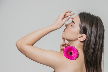 Young beautiful woman relaxing with lotus flower at spa isolated. On white background. Professional...