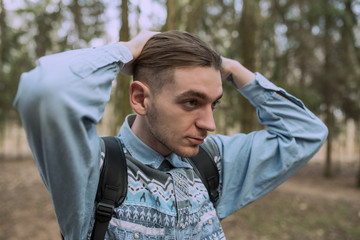 Man Holds His Head with Both Hands and Fixing Hair