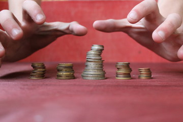hands over the stacks of coins  /  the concept of augmenting revenue by magical means