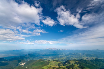 Fototapeta na wymiar Breathtaking panoramic view of magnificent Rucar-Bran area between the Piatra Craiului and Bucegi mountains in the Romanian Carpathians. Natural alpine scenery landscape of mountains and cloudy sky.