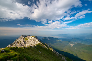 Natural alpine scenery landscape of mountains and dramatic cloudy sky. Breathtaking panoramic view of magnificent Bran area from the Piatra Craiului mountains in the Romanian Carpathians.