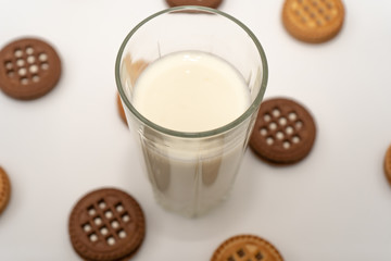 Close-up of a glass of milk and cookies on white background