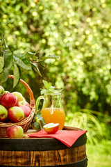 apples on background orchard standing on a barrel. Apple juice and apple preserves.