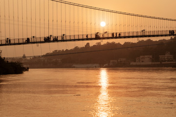 Beautiful view of Ganges river embankment and bridge at sunset. Rishikesh, India