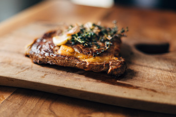 Ribeye steak resting on a wooden board in a restaurant kitchen