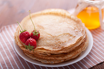 Delicious pancakes with honey and berries.