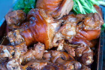 Stewed pork leg, Thai style food. Street food in market, Thailand, close up. Thai local traditional crease brown skin pork leg knuckle stewed with black Chinese sauce