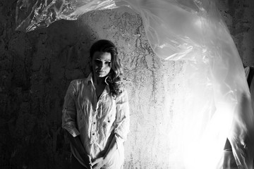  Frau in Hemd hinter Beton Mauer