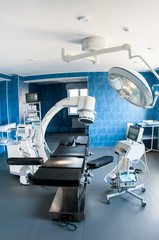 Modern operating room with X-ray medical scan, operating table, special lamp and medical devices.